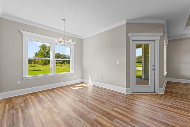 unfurnished room with crown molding, hardwood / wood-style flooring, and an inviting chandelier