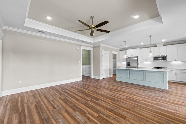 kitchen with a raised ceiling, white cabinetry, and appliances with stainless steel finishes