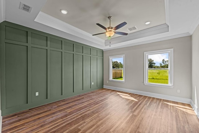 unfurnished bedroom with a tray ceiling, ceiling fan, and crown molding