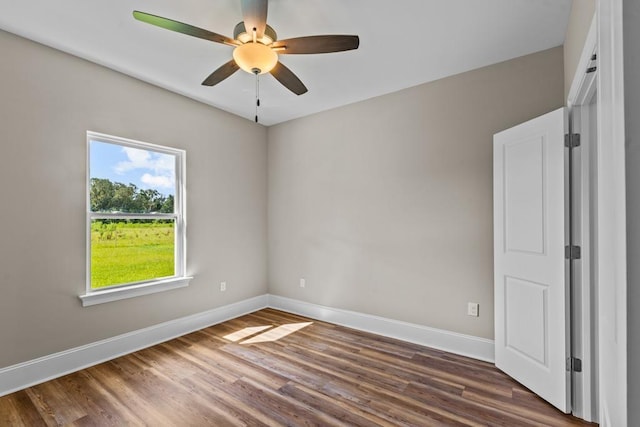 unfurnished room with ceiling fan and dark wood-type flooring