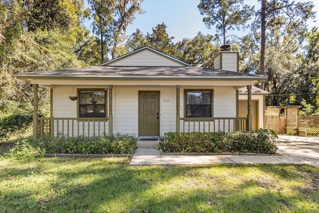 bungalow-style house with a front yard and covered porch