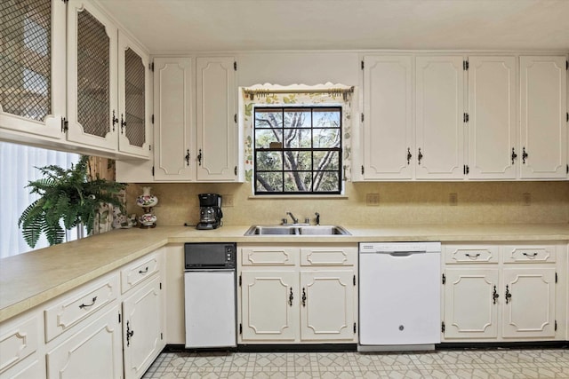 kitchen featuring white cabinetry, dishwasher, sink, and backsplash