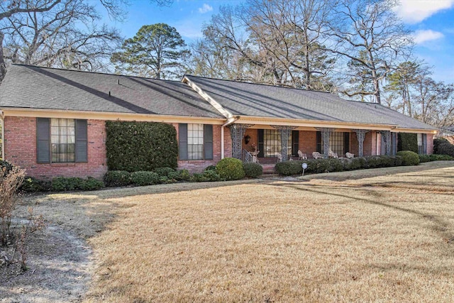 ranch-style home featuring a porch and a front yard