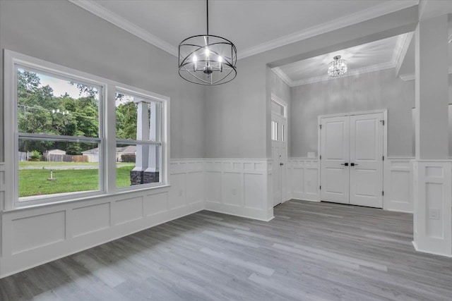 10096 Green Fountain Rd, Tallahassee, FL 32305 - unfurnished dining area with a chandelier, light wood-type flooring, a decorative wall, and wainscoting