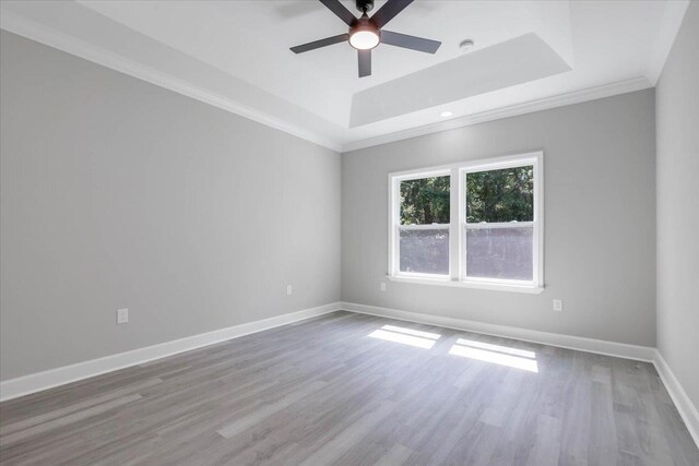 10096 Green Fountain Rd, Tallahassee, FL 32305 - empty room featuring a raised ceiling, ornamental molding, a ceiling fan, wood finished floors, and baseboards