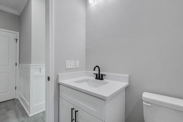 10096 Green Fountain Rd, Tallahassee, FL 32305 - half bathroom with wood finished floors, vanity, toilet, and ornamental molding