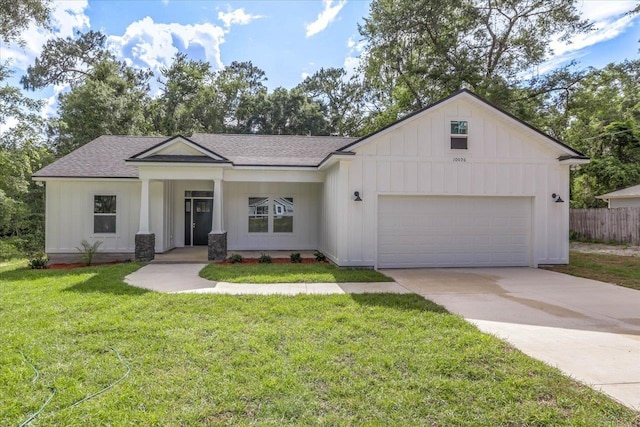 10096 Green Fountain Rd, Tallahassee, FL 32305 - view of front facade featuring board and batten siding, driveway, a garage, a shingled roof, and covered porch
