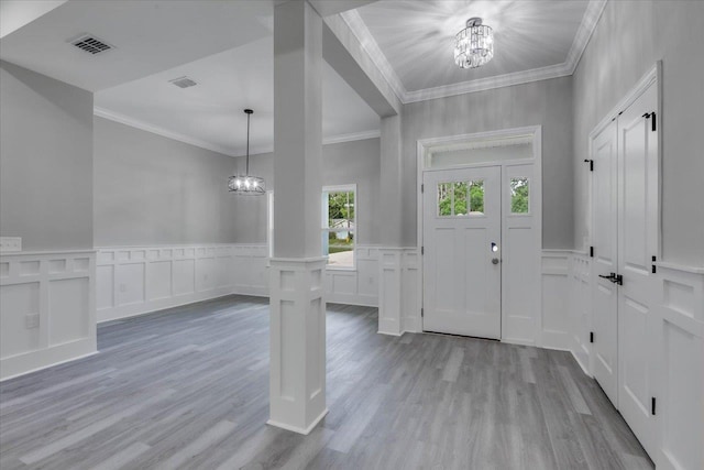 10096 Green Fountain Rd, Tallahassee, FL 32305 - entrance foyer featuring a chandelier, a decorative wall, crown molding, wood finished floors, and wainscoting