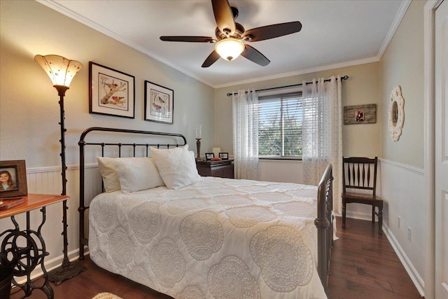 bedroom featuring dark wood finished floors, wainscoting, a ceiling fan, and ornamental molding