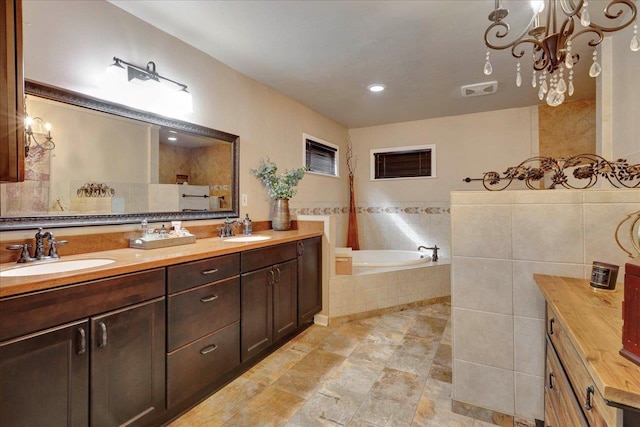 full bath with a sink, visible vents, a garden tub, and double vanity