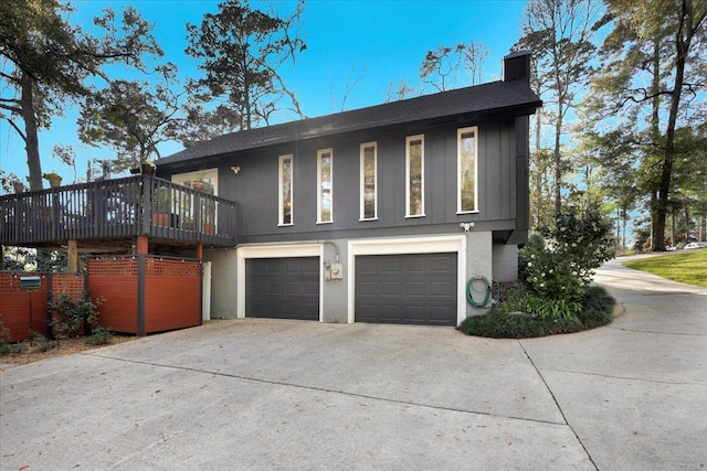 view of home's exterior featuring stucco siding, a garage, driveway, and a chimney