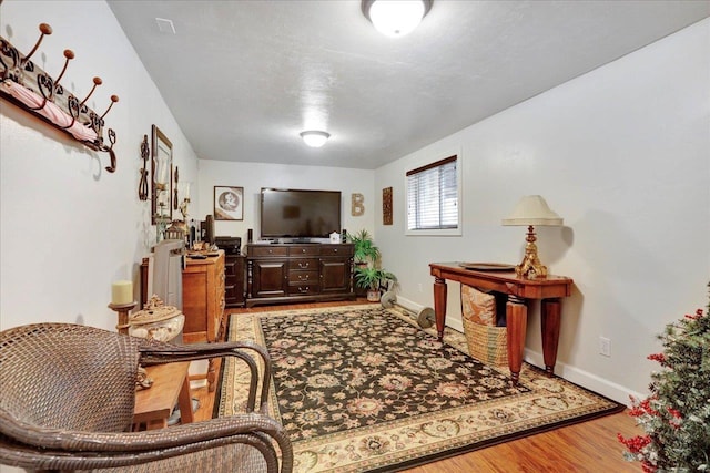 living area with wood finished floors and baseboards