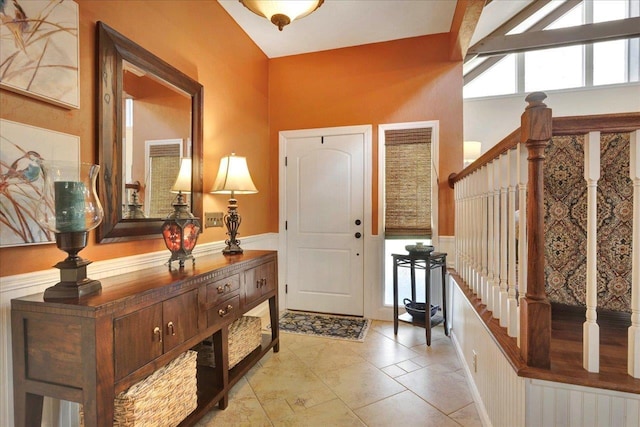 entryway with a wainscoted wall and stairs