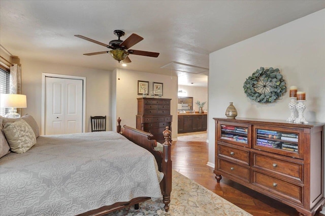 bedroom with baseboards, attic access, ceiling fan, a closet, and wood-type flooring