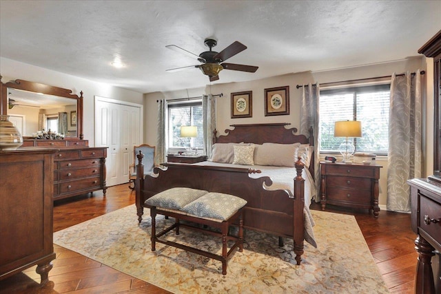 bedroom with a closet, a textured ceiling, and dark wood finished floors