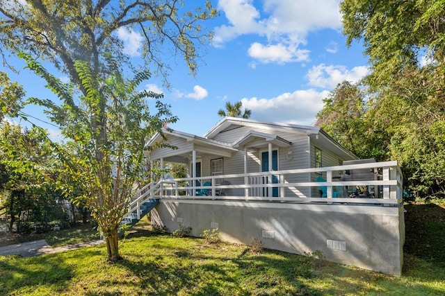 bungalow with covered porch and a front yard