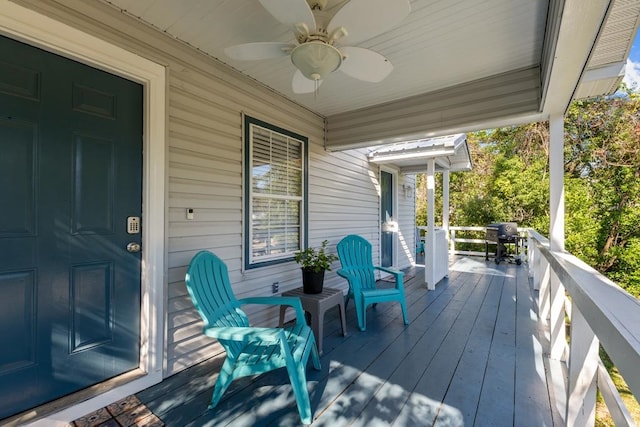 wooden terrace with a porch, ceiling fan, and area for grilling