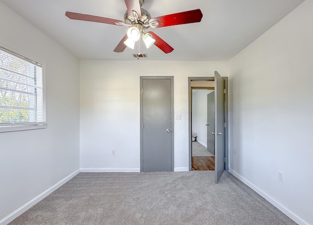 unfurnished bedroom with baseboards, carpet floors, visible vents, and a ceiling fan