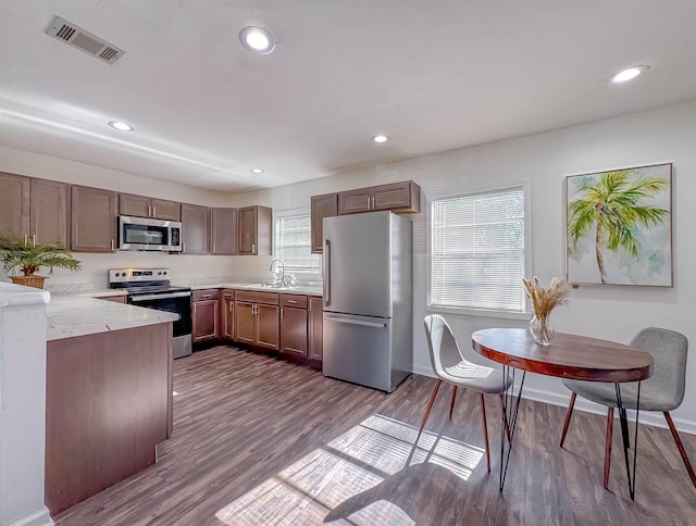 kitchen with visible vents, dark wood finished floors, a sink, light countertops, and appliances with stainless steel finishes