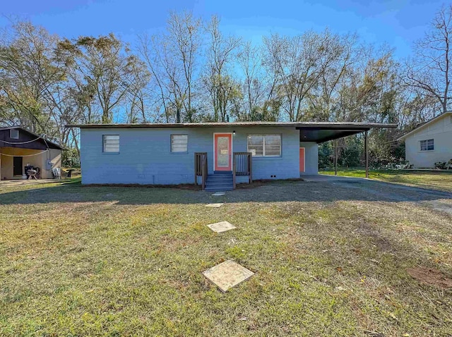 view of front of home with an attached carport, driveway, concrete block siding, and a front yard