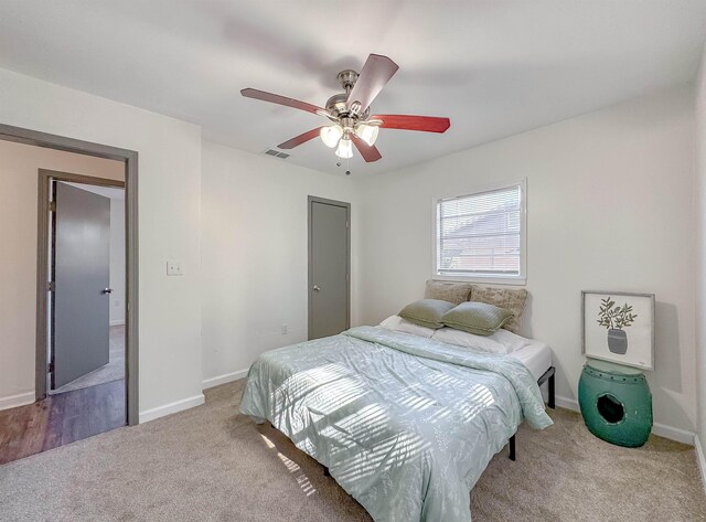 carpeted bedroom with baseboards, visible vents, and ceiling fan