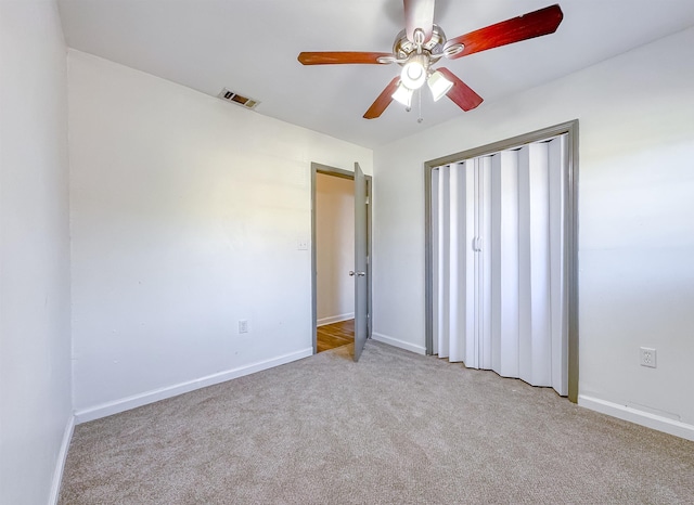 unfurnished bedroom with visible vents, baseboards, light colored carpet, and a closet