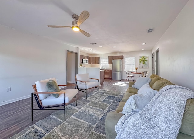 living room with visible vents, baseboards, recessed lighting, wood finished floors, and a ceiling fan