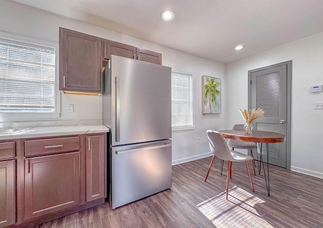 kitchen featuring plenty of natural light, light wood-style flooring, light countertops, and freestanding refrigerator