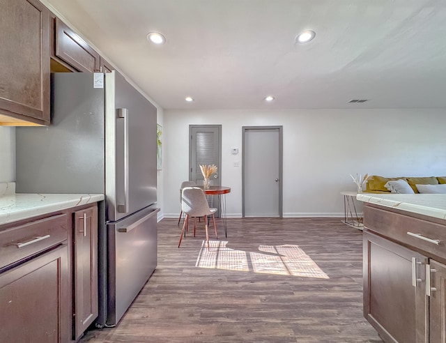 kitchen with visible vents, recessed lighting, freestanding refrigerator, and wood finished floors