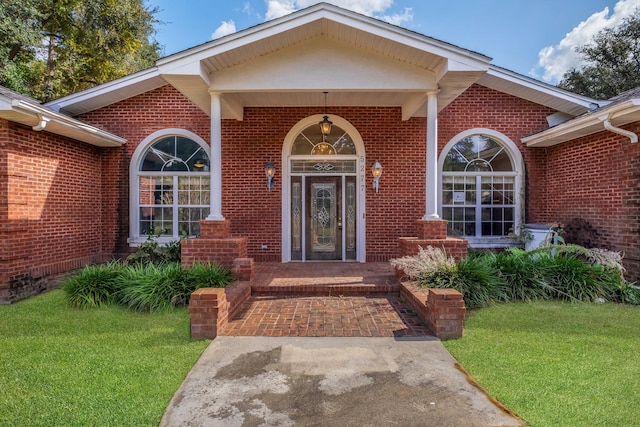 view of exterior entry with a lawn