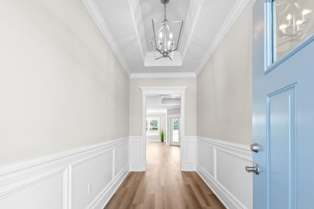 hallway featuring ornamental molding, dark hardwood / wood-style floors, and a notable chandelier