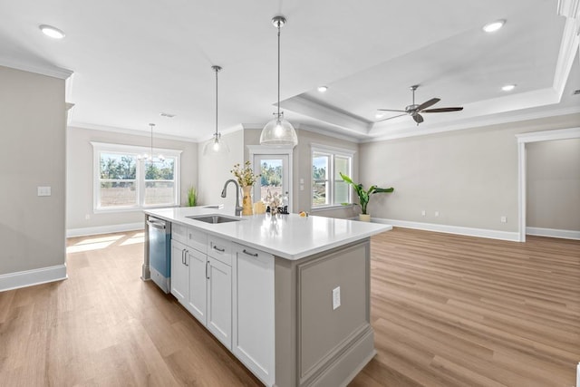 kitchen featuring dishwasher, sink, white cabinets, hanging light fixtures, and a kitchen island with sink