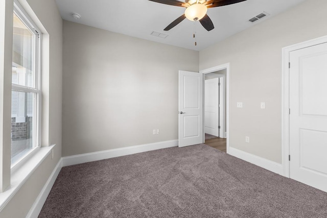 unfurnished bedroom featuring ceiling fan, carpet, and multiple windows