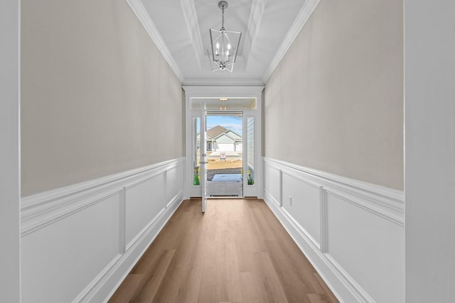 entryway with crown molding, a chandelier, and hardwood / wood-style flooring