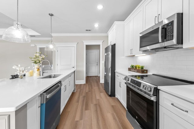 kitchen featuring pendant lighting, white cabinetry, sink, stainless steel appliances, and crown molding