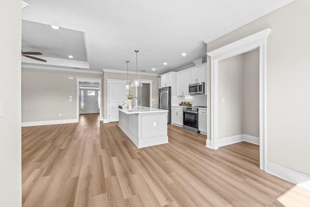 kitchen featuring a center island with sink, appliances with stainless steel finishes, pendant lighting, ceiling fan, and white cabinets