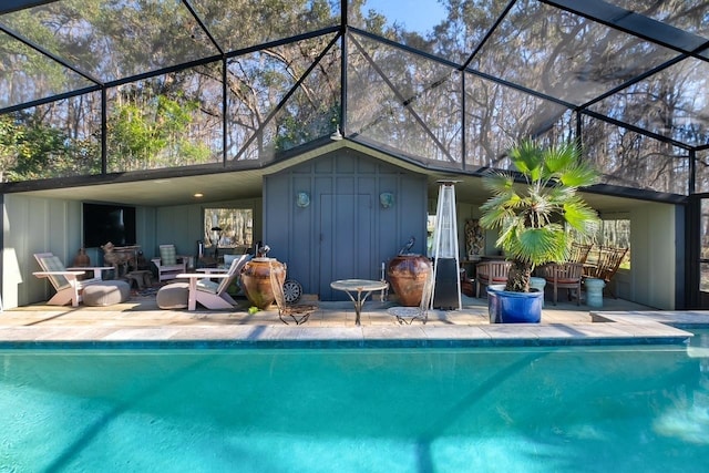 view of pool featuring glass enclosure and a patio area