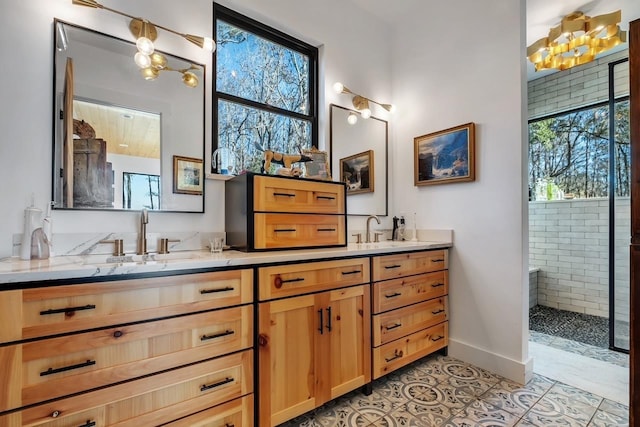 bathroom with tile patterned flooring, vanity, and a tile shower