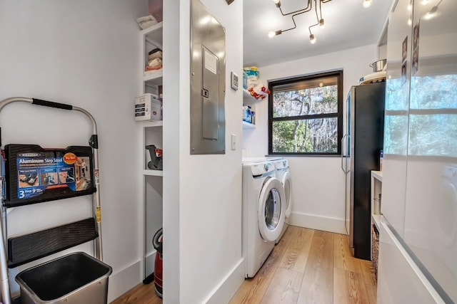 washroom featuring independent washer and dryer, light wood-type flooring, and electric panel