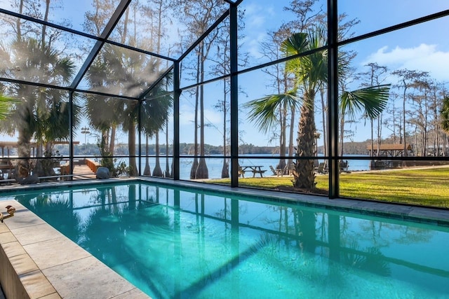 view of swimming pool featuring glass enclosure and a water view