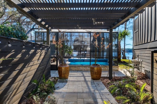 view of patio with a pergola, a water view, and a pool