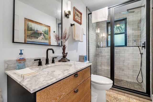 bathroom featuring vanity, toilet, and an enclosed shower