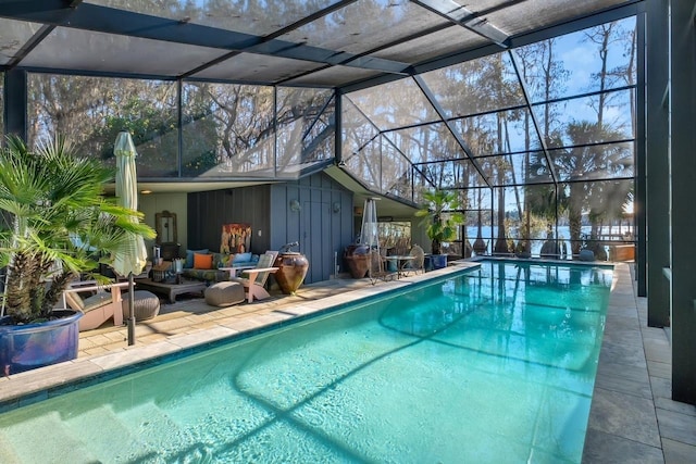 view of swimming pool featuring glass enclosure and a patio area