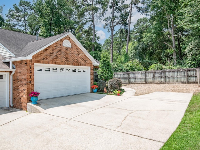 7214 Jaffrey Ct, Tallahassee, FL 32312 - garage featuring view of scattered trees and driveway