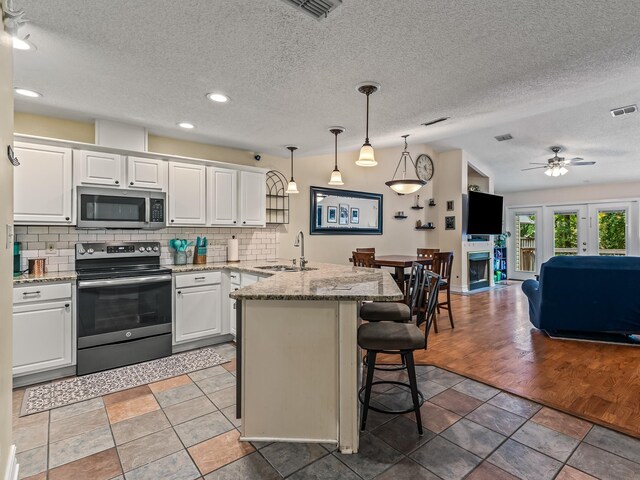 7214 Jaffrey Ct, Tallahassee, FL 32312 - kitchen featuring appliances with stainless steel finishes, a peninsula, a sink, open floor plan, and a breakfast bar area