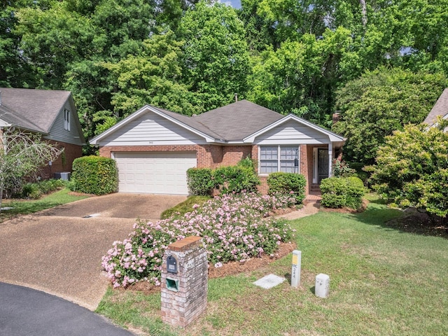 single story home featuring a garage, a front yard, driveway, and brick siding