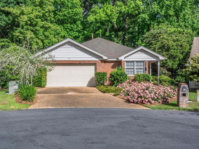 single story home featuring concrete driveway, brick siding, and an attached garage