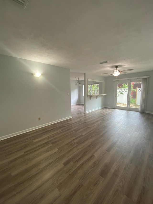 empty room featuring dark hardwood / wood-style flooring and ceiling fan with notable chandelier