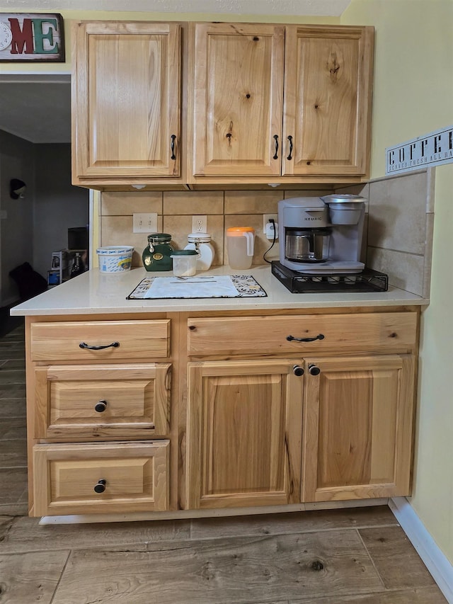 kitchen featuring wood-type flooring, light brown cabinets, and decorative backsplash