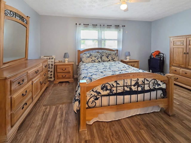 bedroom featuring ceiling fan, wood-type flooring, and a textured ceiling